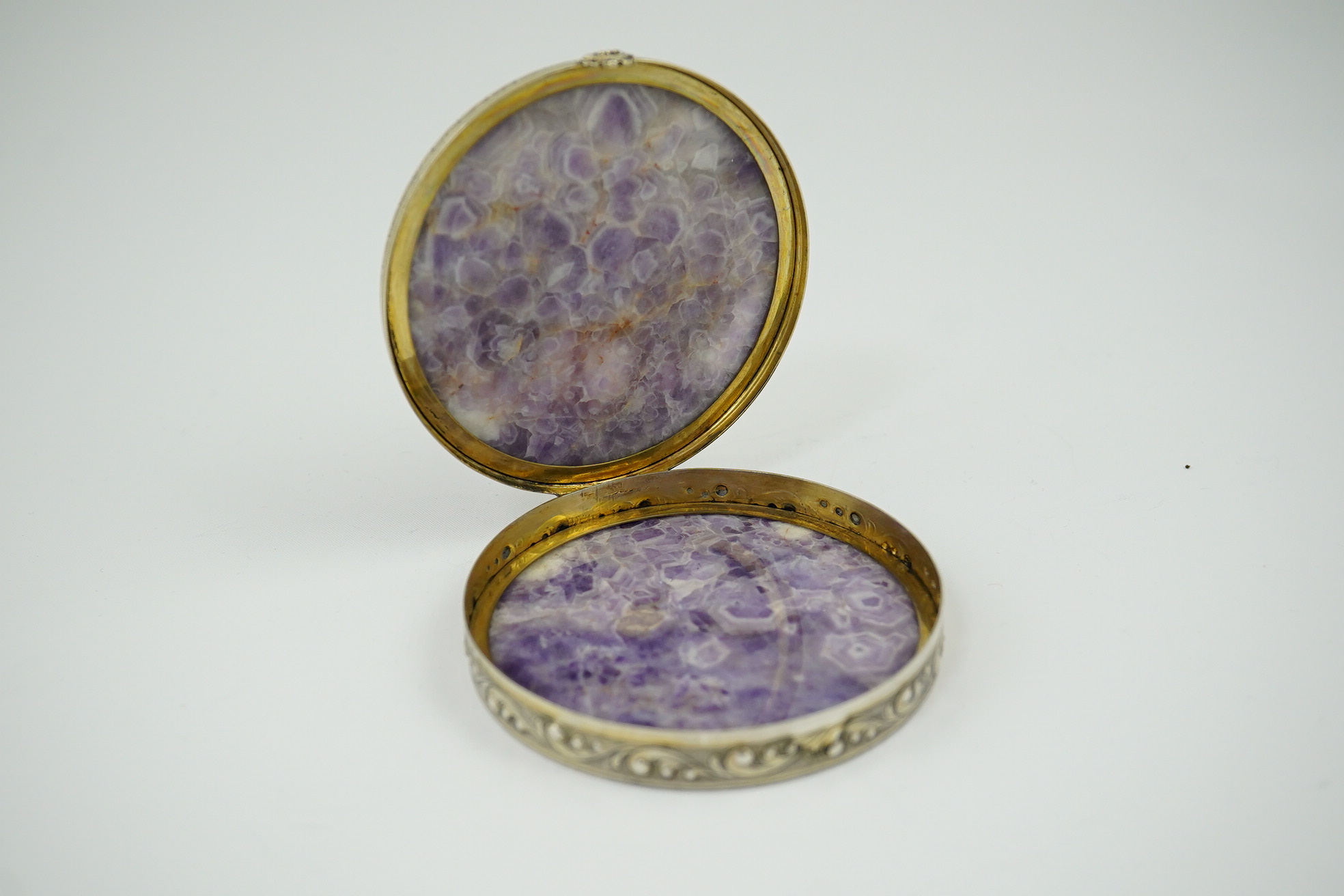 An early 20th century pierced parcel gilt silver mounted amethyst circular box and cover